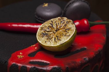 Kek ile siyah kadife kaplı. kireç, biber ve macaroons, üstte kırmızı sır. portre vurdu