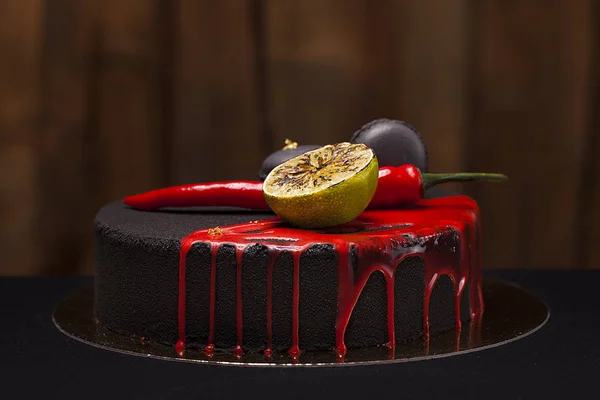 Kuchen mit schwarzem Samt bedeckt. mit Limette, Chilischote und Makronen, rote Glasur darüber — Stockfoto