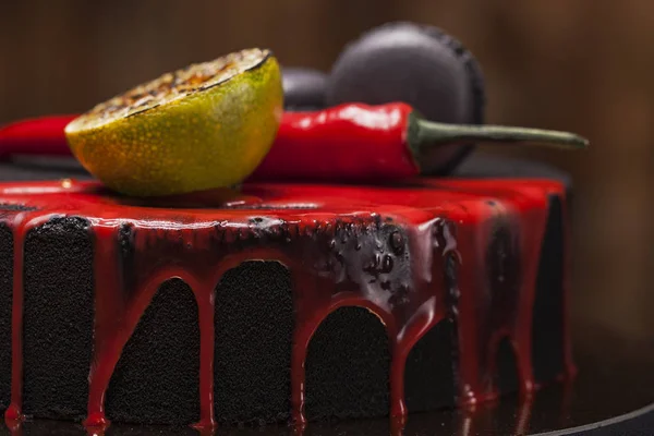 Cake covered with black velvet. with lime, chili pepper and macaroons, red glaze on top. made by professional chef — Stock Photo, Image