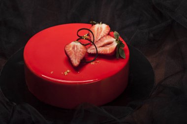 Çilekli pasta kırmızı ayna sır ile kaplı berry parçaları, altın ve çikolata ile dekore edilmiş