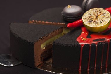 Kek ile siyah kadife kaplı. kireç, biber ve macaroons, üstte kırmızı sır. kesilmiş bir parça ile