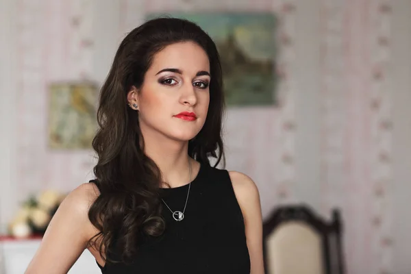 Portrait of a beautiful young girl with red lips, brunette curls and black clothes — Stock Photo, Image