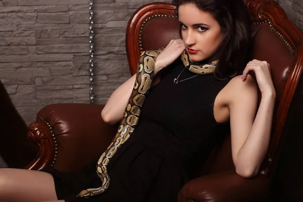 Portrait of sexy woman with snake in black dress smiling, red lips — Stock Photo, Image