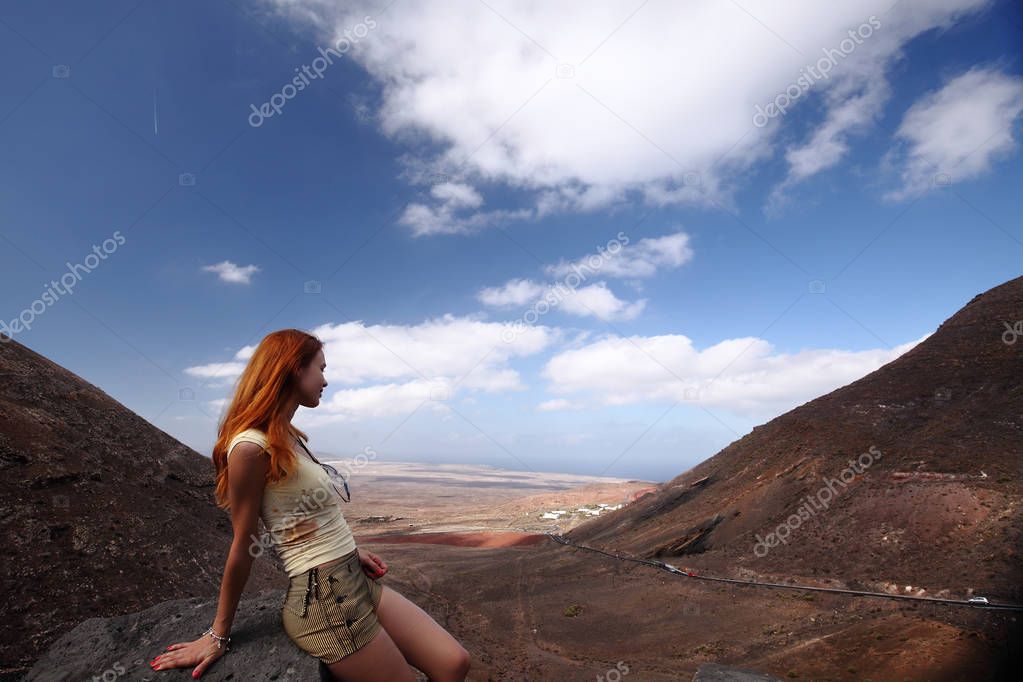 girl watching Lanzarote landscape through hills, Canary Islands, Spain.