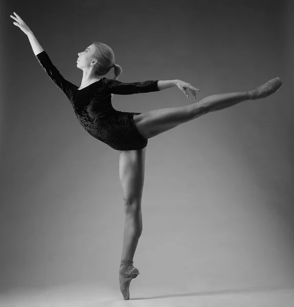 Die schöne Ballerina posiert und tanzt im Studio. klassische Ballettkunst. auf einem Zeh stehend. Schwarz-Weiß-Bild — Stockfoto