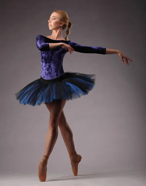 Jonge en ongelooflijk mooie ballerina in blauwe outfit is poseren en dansen in de studio. klassieke — Stockfoto