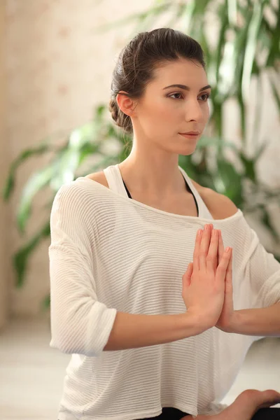 Yoga a casa. giovane donna seduta sulla posizione del loto sul pavimento con gli occhi chiusi . — Foto Stock