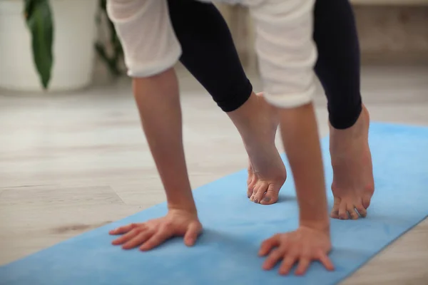 Joven mujer yogui atractiva practicando yoga, tratando de hacer pose de Grulla, primer plano con las manos y las piernas —  Fotos de Stock