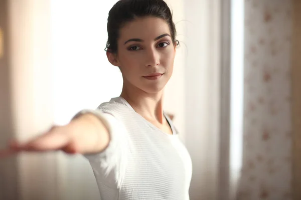 Yoga en casa. Atractiva morena haciendo yoga en casa, por la mañana. primer plano guerrero — Foto de Stock