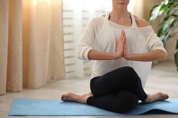 Yoga hemma. Attraktiv oigenkännlig kvinna göra yoga hemma, morgon tidpunkt. vit skjorta och barfota — Stockfoto