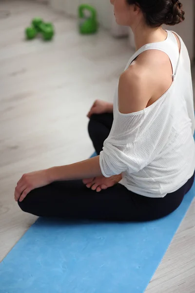 Yoga hemma. Attraktiv oigenkännlig kvinna sitter på lotus ställning på golvet, sköt tillbaka — Stockfoto