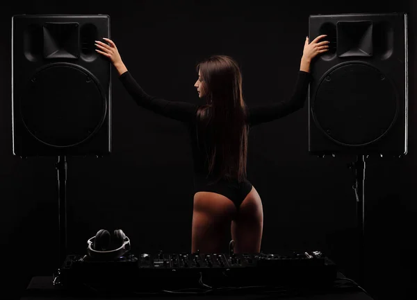Sexy jonge meisje met perfecte lichaam dans tussen twee grote zwarte luidsprekers, met ezel — Stockfoto