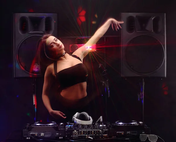 Sexy woman dj playing music on mixer and dancing with light beam effects. slow sync flash technique — Stock Photo, Image