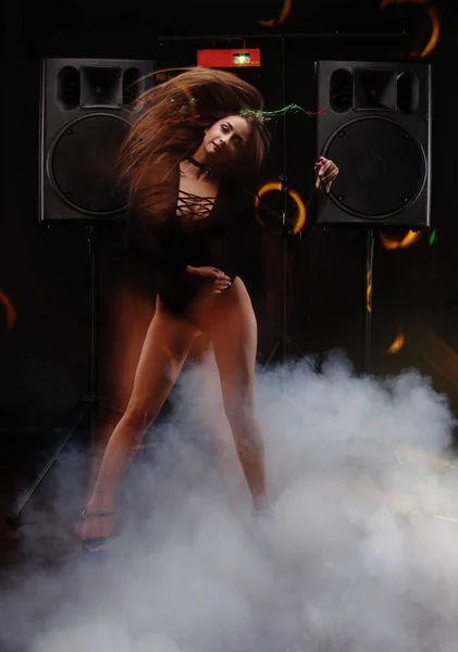Sexy chica joven con perfecto cuerpo danza gogo im humo cerca de dos grandes altavoces negros. técnica de flash de sincronización lenta — Foto de Stock
