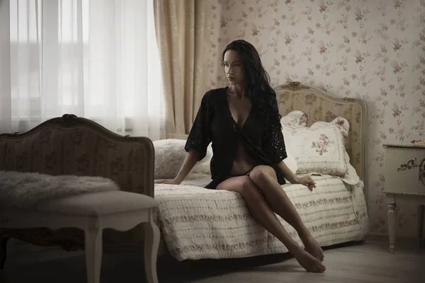 Vacker sexig kvinna som bär förföriska underkläder sitta på sängen — Stockfoto