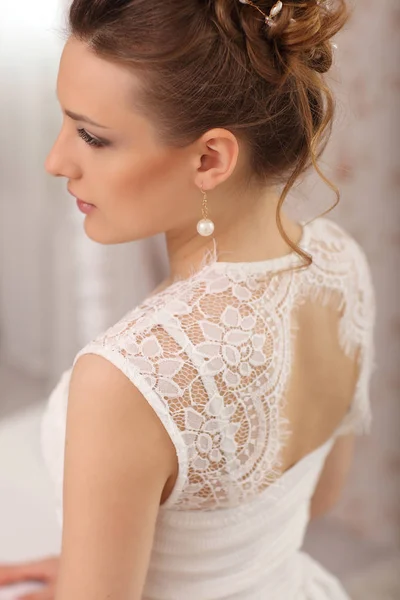 Retrato de modelo de noiva bonita com maquiagem perfeita e estilo de cabelo na sala de luz em casa — Fotografia de Stock