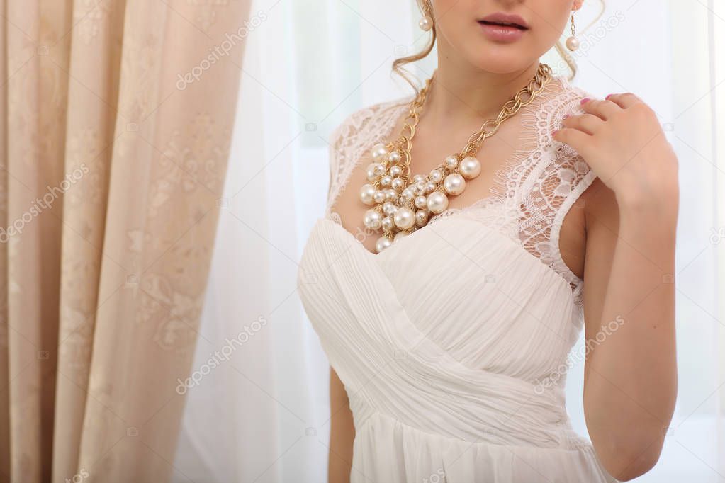Wedding. unrecognizable Bride in beautiful white dress standing near window indoors in studio interior like at home