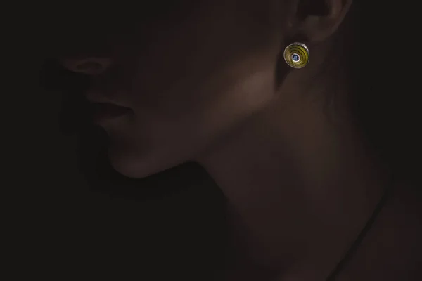 exclusive jewelry accessories concept. dark picture with bright earring on woman. luxury.