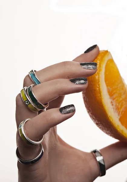 Delikatne ręce z orange i pierścienie na. Reklama biżuteria. na białym tle. — Zdjęcie stockowe