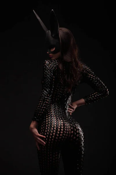 Ritratto di sexy bruna donna in posa in coniglio maschera nera e body indietro colpo . — Foto Stock