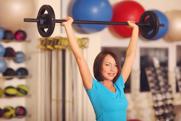 Bodybuilding. kvinna som tränar med skivstång i fitness klass. Kvinnliga träningspass i gymmet med skivstång. — Stockfoto