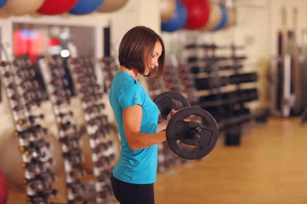 Culturismo. mujer haciendo ejercicio con barbell. chica levantando pesas en el gimnasio —  Fotos de Stock