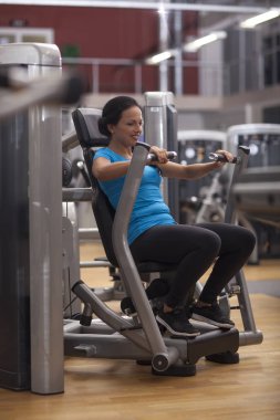 Vücut geliştirme. egzersiz-makine silah geri ve omuzları ile spor salonunda egzersiz kadın