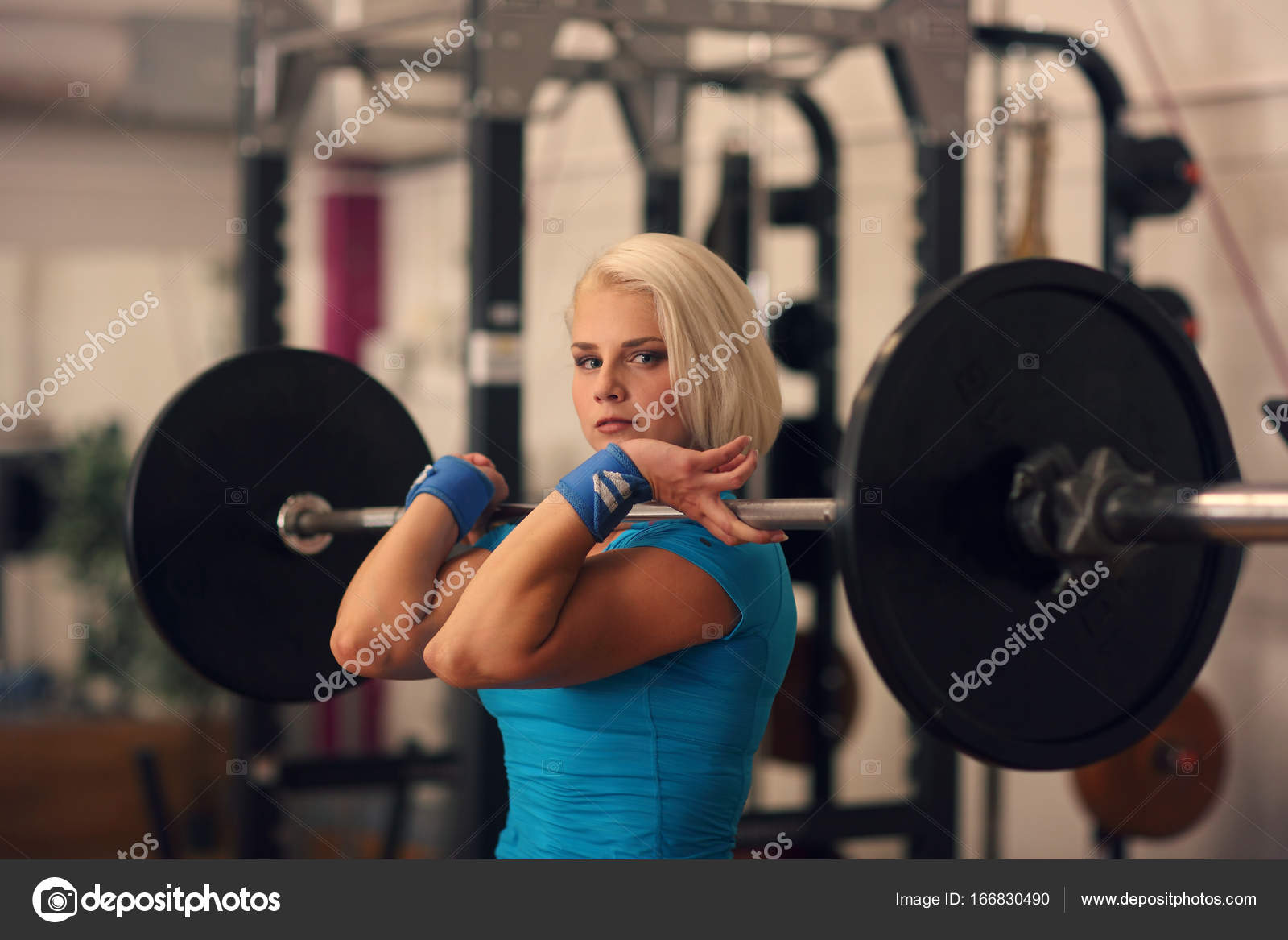 Bodybuilding. Strong fit woman exercising with barbell. girl doing squats  with big weights Stock Photo by ©fenixlive 166830490