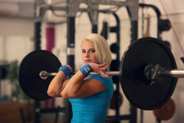 Bodybuilding. Ισχυρή ταιριάζουν γυναίκα άσκησης με barbell. κορίτσι κάνει καταλήψεις με μεγάλα βάρη — Φωτογραφία Αρχείου