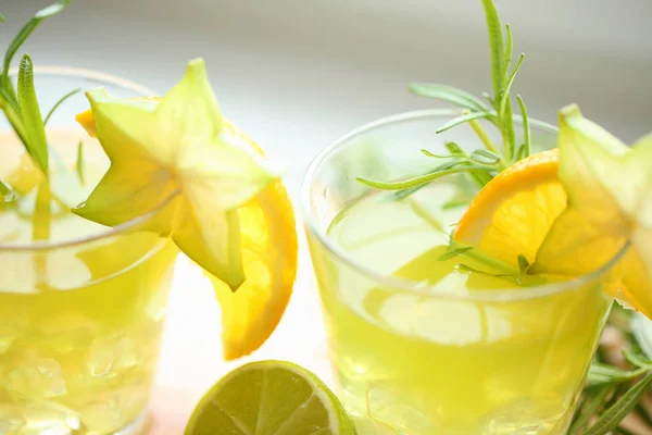 Concetto di cocktail - tre cocktail verdi spiccano sul legno, decorato con arancia, carambola, lime e rosmarino. Pronto per la festa — Foto Stock