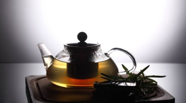 Biberiye ve çikolata yakınındaki, stüdyo çekim ile ahşap kesme tahtası üzerinde bitki çayı ile çaydanlık