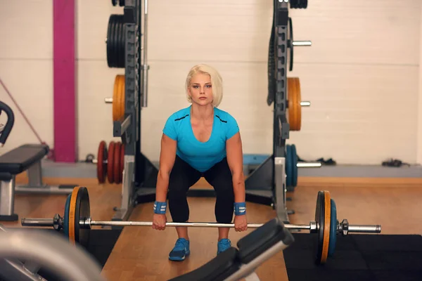 Bodybuilding. Strong fit woman exercising with barbell. girl doing squats with big weights — Stock Photo, Image