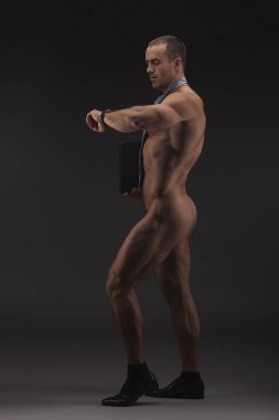 Kravat giyen kaslı seksi çıplak adam ile ağıl, çizme ve sadece çorap