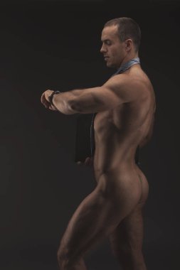 Kravat giyen kaslı seksi çıplak adam ile ağıl, çizme ve sadece çorap