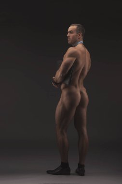 Kravat giyen kaslı seksi çıplak adam ile ağıl, çizme ve sadece çorap