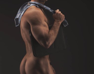 Kravat giyen kaslı seksi çıplak adam ile ağıl, çizme ve sadece çorap