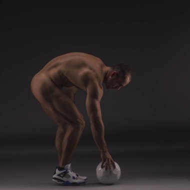 Futbol topu ile son derece kaslı seksi çıplak adam. Güçlü çıplak erkek vücut damarlı