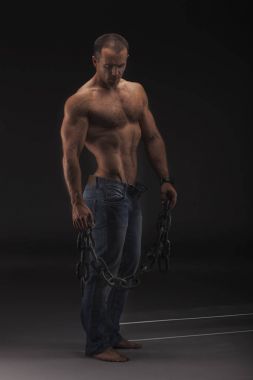 büyük zincirinde sadece kot kaslı seksi adam. Güçlü çıplak erkek vücut damarlı