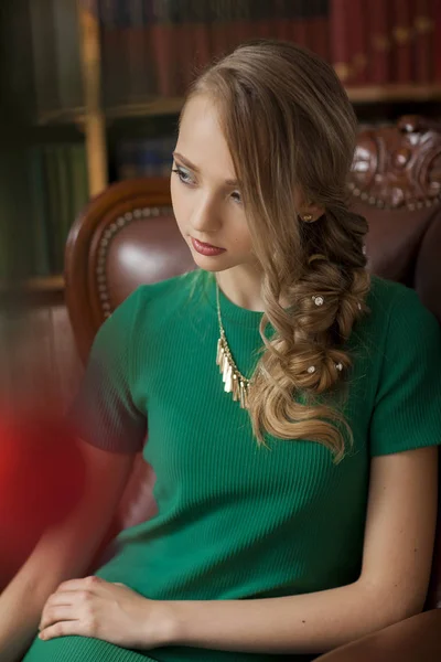 Hermosa modelo de moda con vestido verde en el estudio en el fondo iluminado con verde. Navidad — Foto de Stock