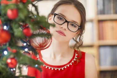 Studio ile yeşil ışıklı arka plan üzerinde kırmızı elbise giymiş güzel bir modeldir. Noel