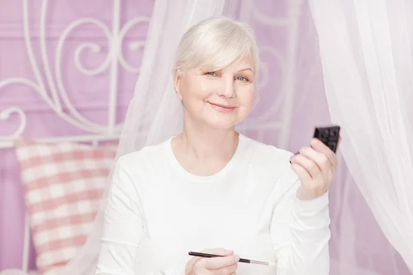 Senior senhora fazendo maquiagem . — Fotografia de Stock