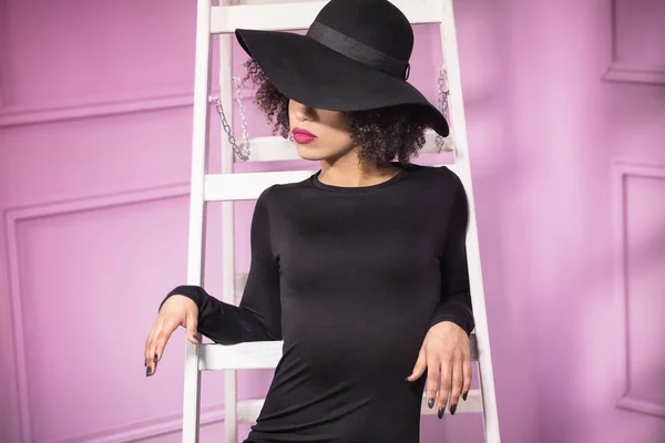 Fashionabla flicka i svart hatt poserar. — Stockfoto