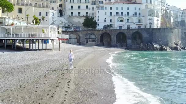 Giovane donna bionda caucasica che si rilassa sulla spiaggia al mattino - Costiera Amalfitana, Italia . — Video Stock