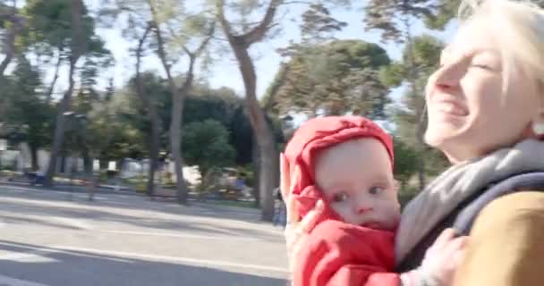 Giovane bella madre caucasica che cammina con il suo bambino in città, sorridendo. Tempo libero felice famiglia. — Video Stock