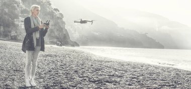 Genç kız dron İtalyan sahil üzerinde uçan.