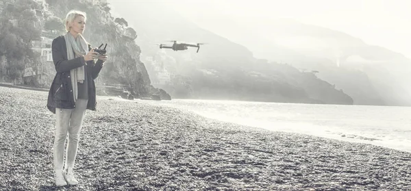 Jovem garota sobrevoando drone costa italiana. — Fotografia de Stock