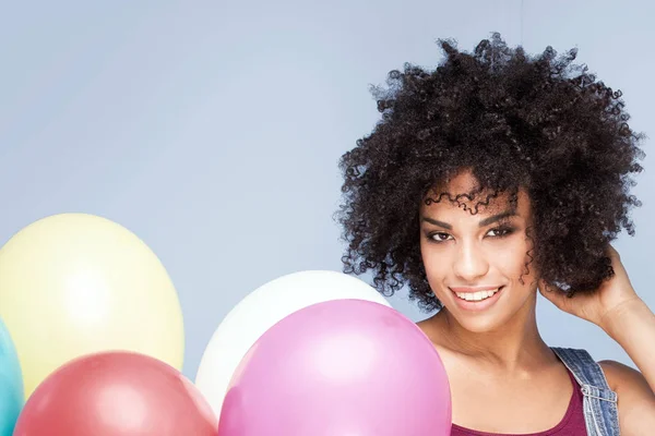 Gelukkig jong meisje met afro houden ballonnen. — Stockfoto