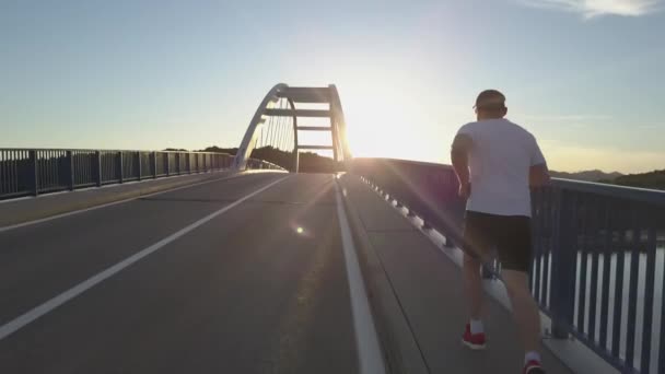 Drone aéreo tiro de jovem desportista correndo na ponte na Croácia . — Vídeo de Stock