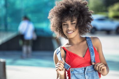 Poz, gülümseyen afro kızla.