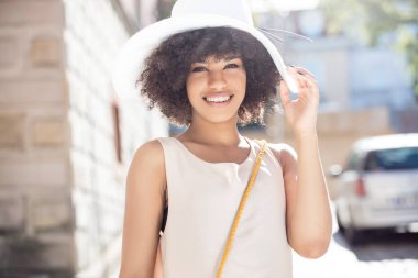 Poz, gülümseyen afro kızla.